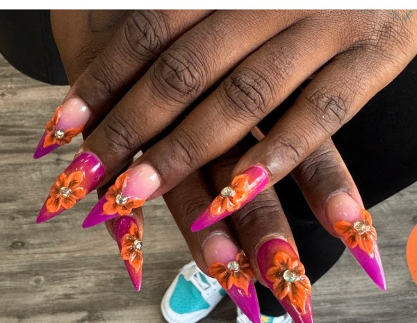 Pink and orange stiletto nails with sculpted floral art