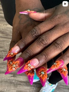 Orange stiletto nails with sculpted floral 3D art